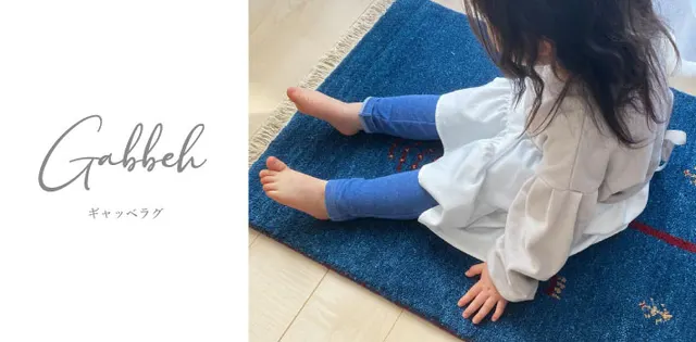 青いギャッベマットに触れる子ども